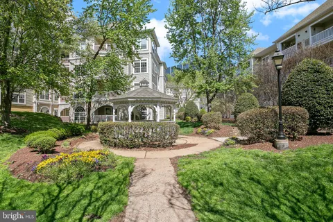 a front view of a house with a garden and trees
