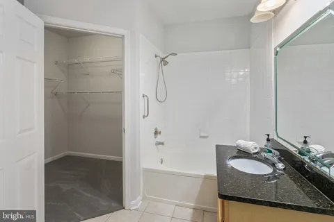 a bathroom with a granite countertop sink a shower and a mirror