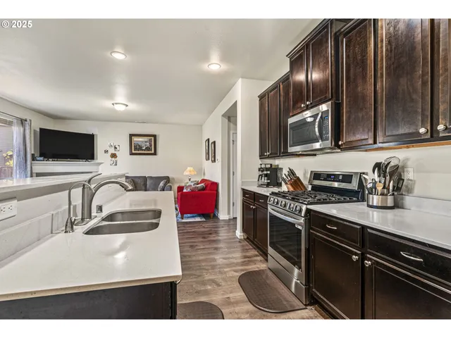 a kitchen with stainless steel appliances granite countertop a sink stove and refrigerator