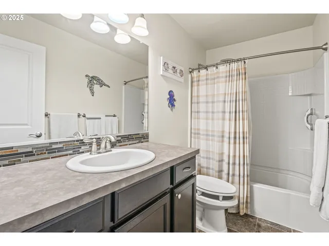 a bathroom with a sink a toilet a mirror a vanity and shower