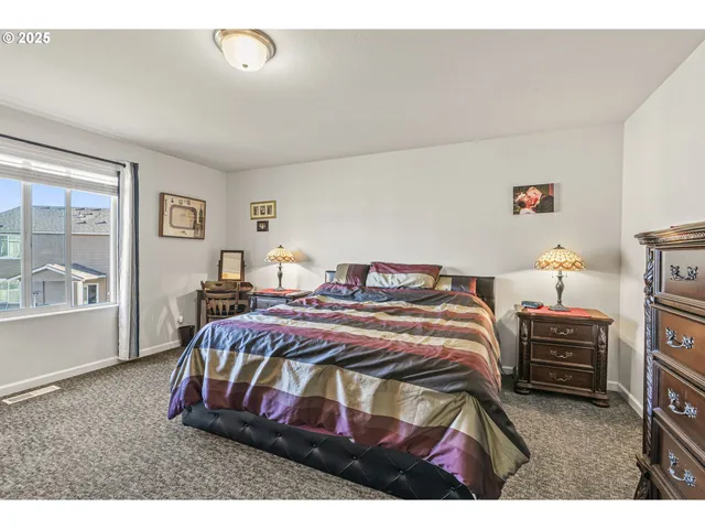 a bedroom with a bed and dresser with mirror