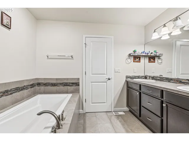 a bathroom with a tub sink and mirror