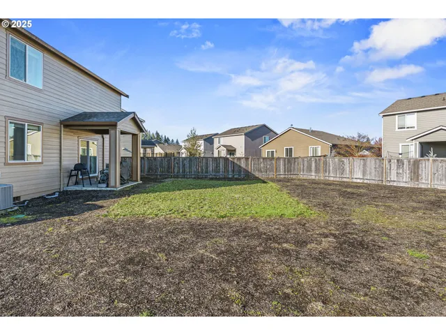 a view of a house with a yard and wooden fence