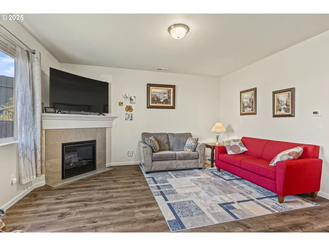 a living room with furniture a flat screen tv and a fireplace