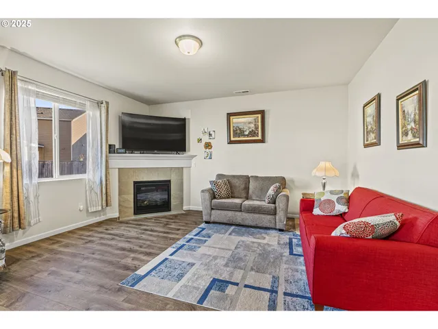 a living room with furniture a flat screen tv and a fireplace