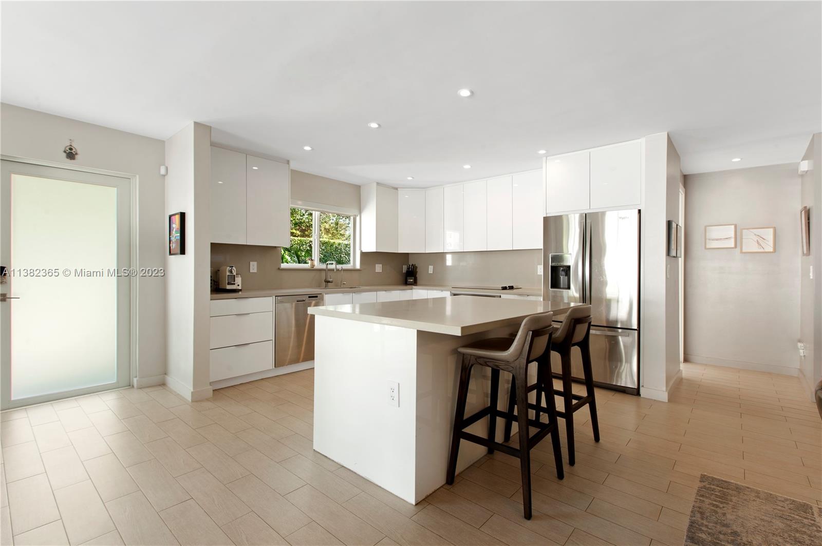 5356 Sunset Drive Miami, FL 33143 - Photo 14 of 29 a kitchen with a refrigerator a table and chairs in it