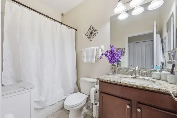 a bathroom with a granite countertop sink a toilet and a mirror