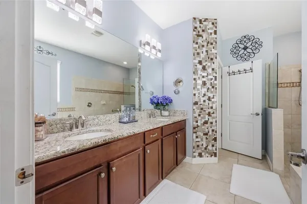 a bathroom with a granite countertop sink a shower and a mirror