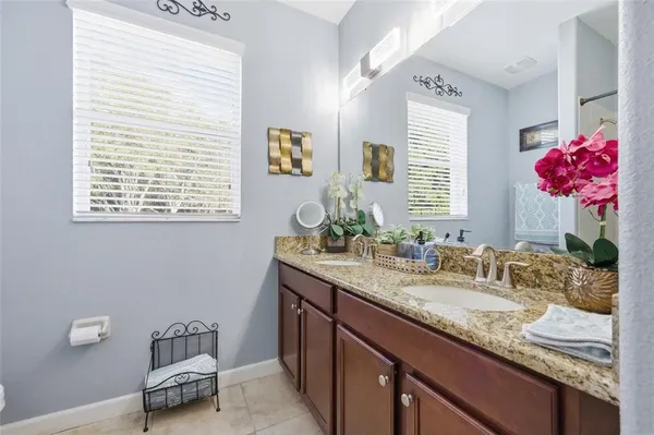 a bathroom with a granite countertop sink a large mirror and a window