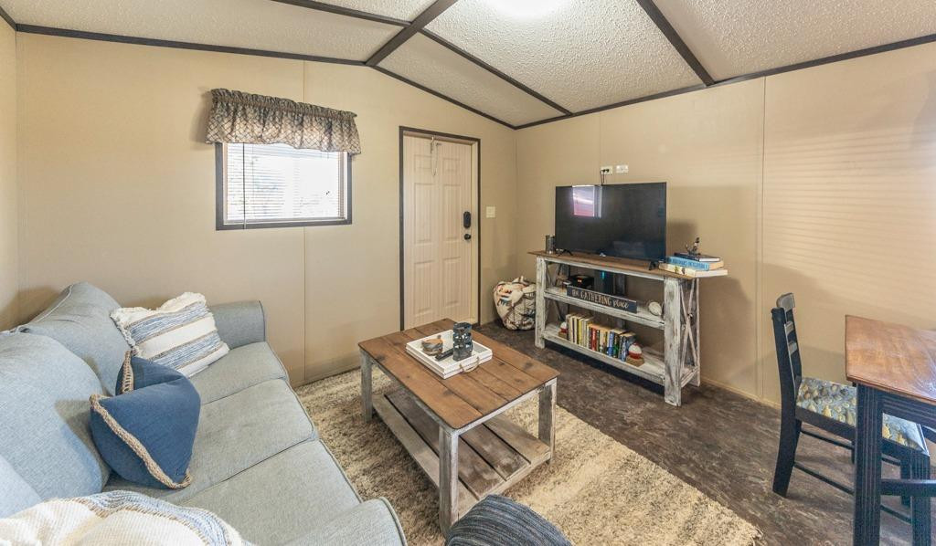 145 Lakesite Drive Spur, TX 79370 - Photo 5 of 20 a living room with furniture a flat screen tv and a wall painting
