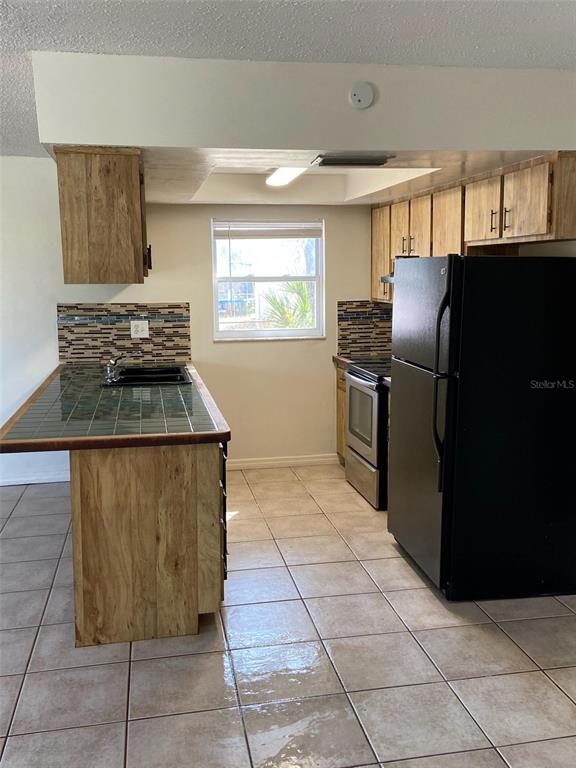 6429 Langston Avenue New Port Richey, FL 34653 - Photo 4 of 14 a kitchen with granite countertop a refrigerator and a stove
