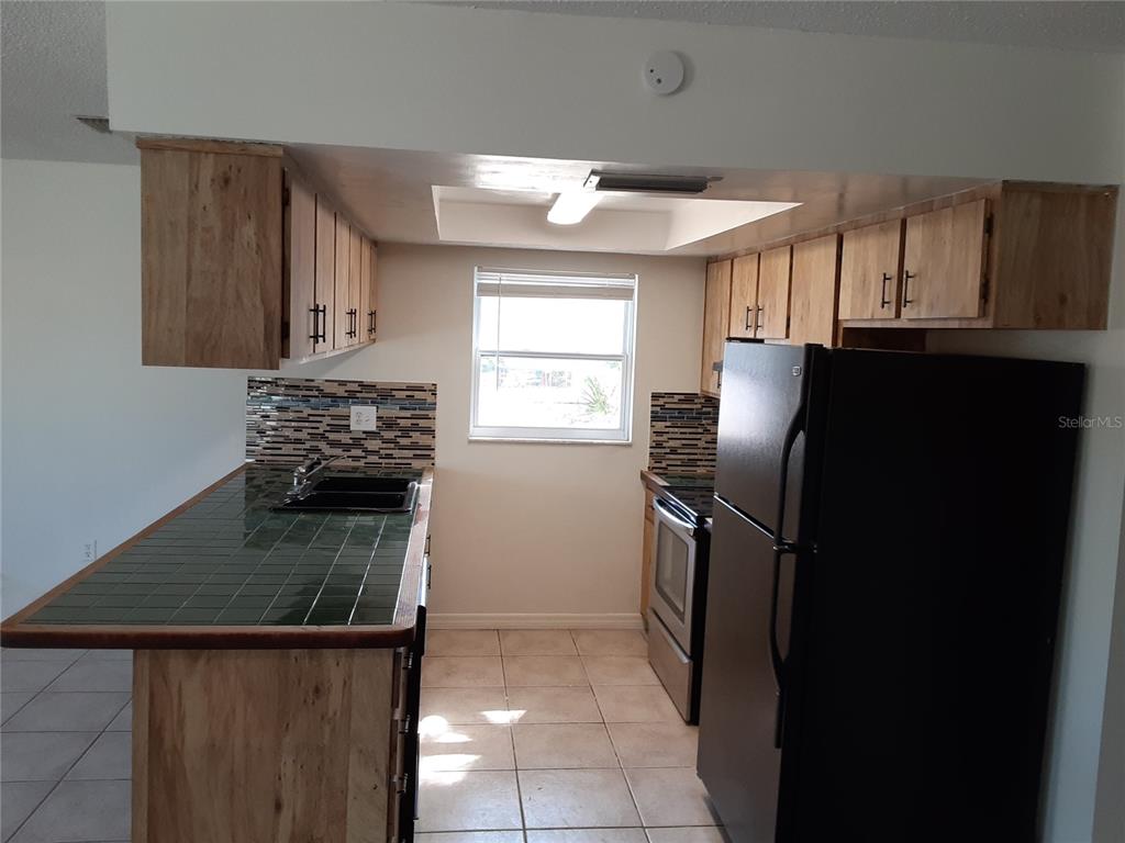 6429 Langston Avenue New Port Richey, FL 34653 - Photo 5 of 14 a kitchen with a refrigerator and a stove