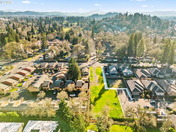 an aerial view of residential house with yard and mountain view in back