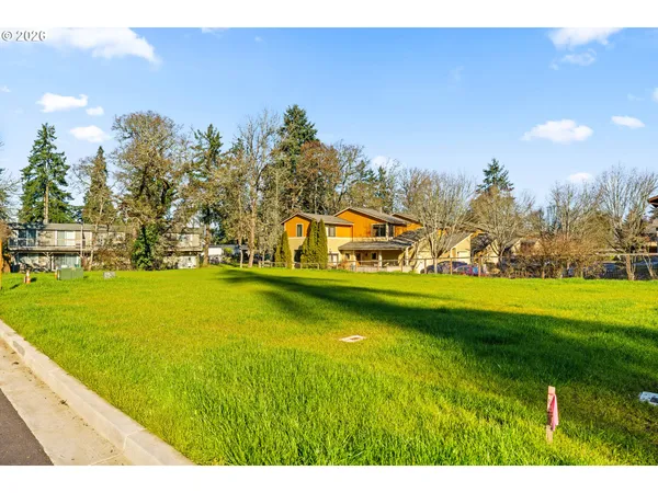 a view of yard with swimming pool and trees in the background