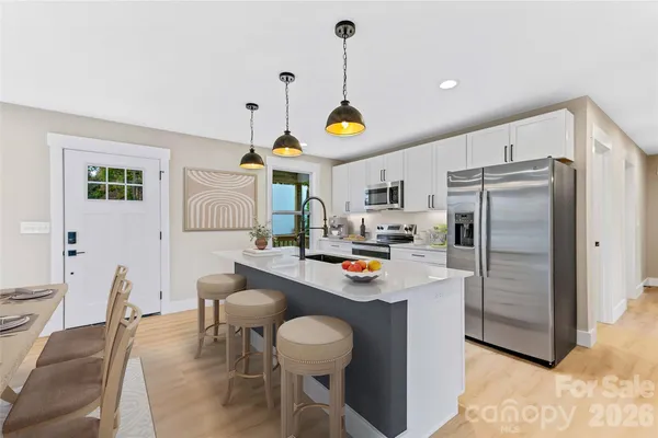 a kitchen with kitchen island a counter space a sink appliances and cabinets