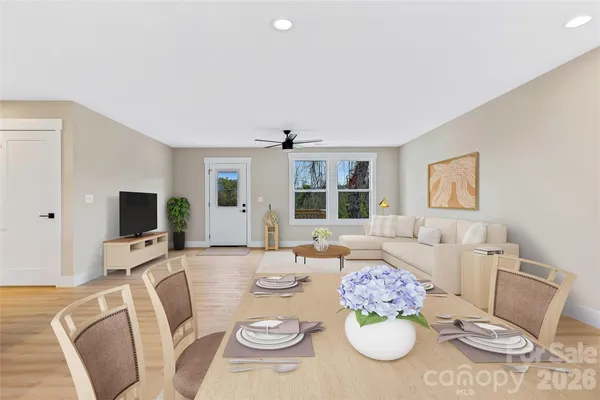 a view of a dining room with furniture a rug and wooden floor