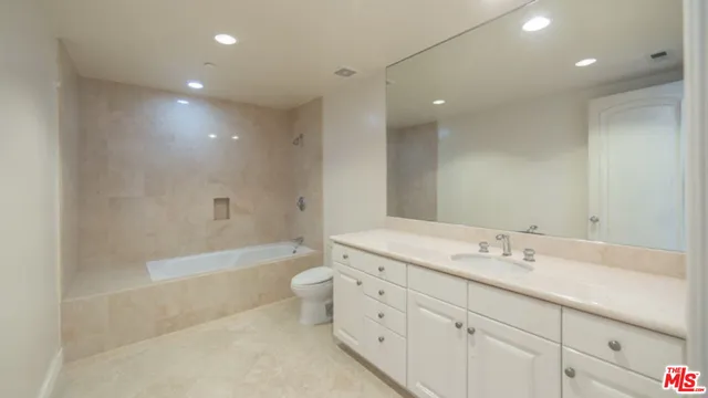 a large bathroom with a large mirror vanity and a shower