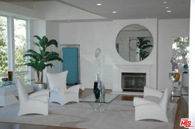 a living room with furniture a potted plant and a fireplace