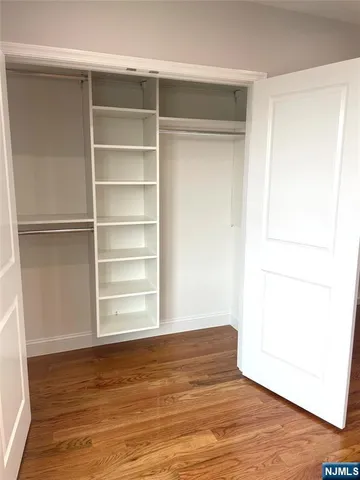 a view of a room with wooden floor and a window