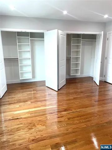 an empty room with wooden floor and closet