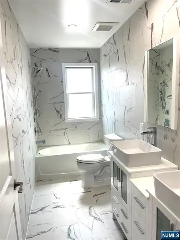 a bathroom with a sink toilet tub and shower