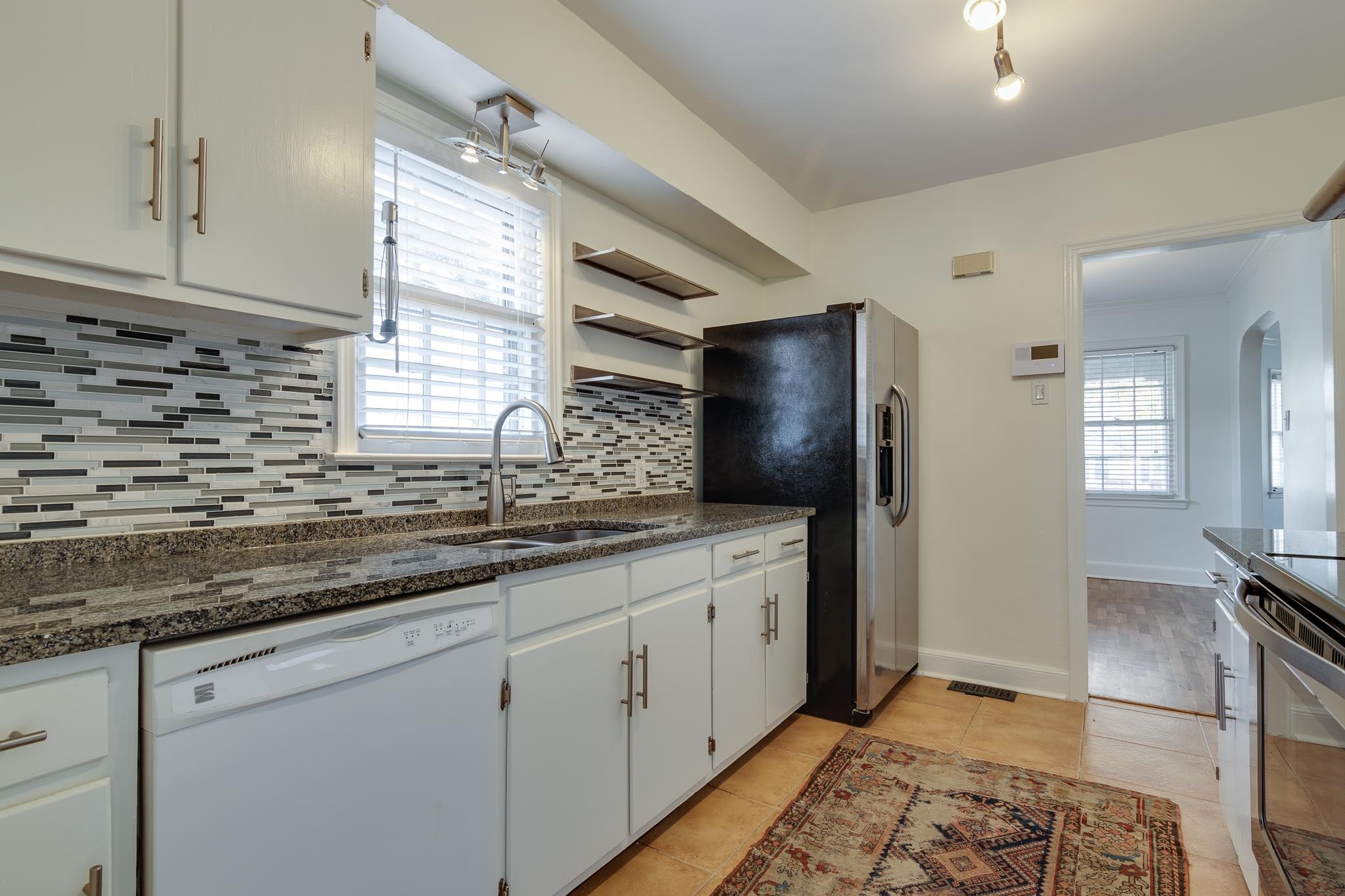 2767 Iroquois Road Memphis, TN 38111 - Photo 13 of 28 Kitchen with backsplash, sink, white cabinetry, dishwasher, and light tile patterned floors