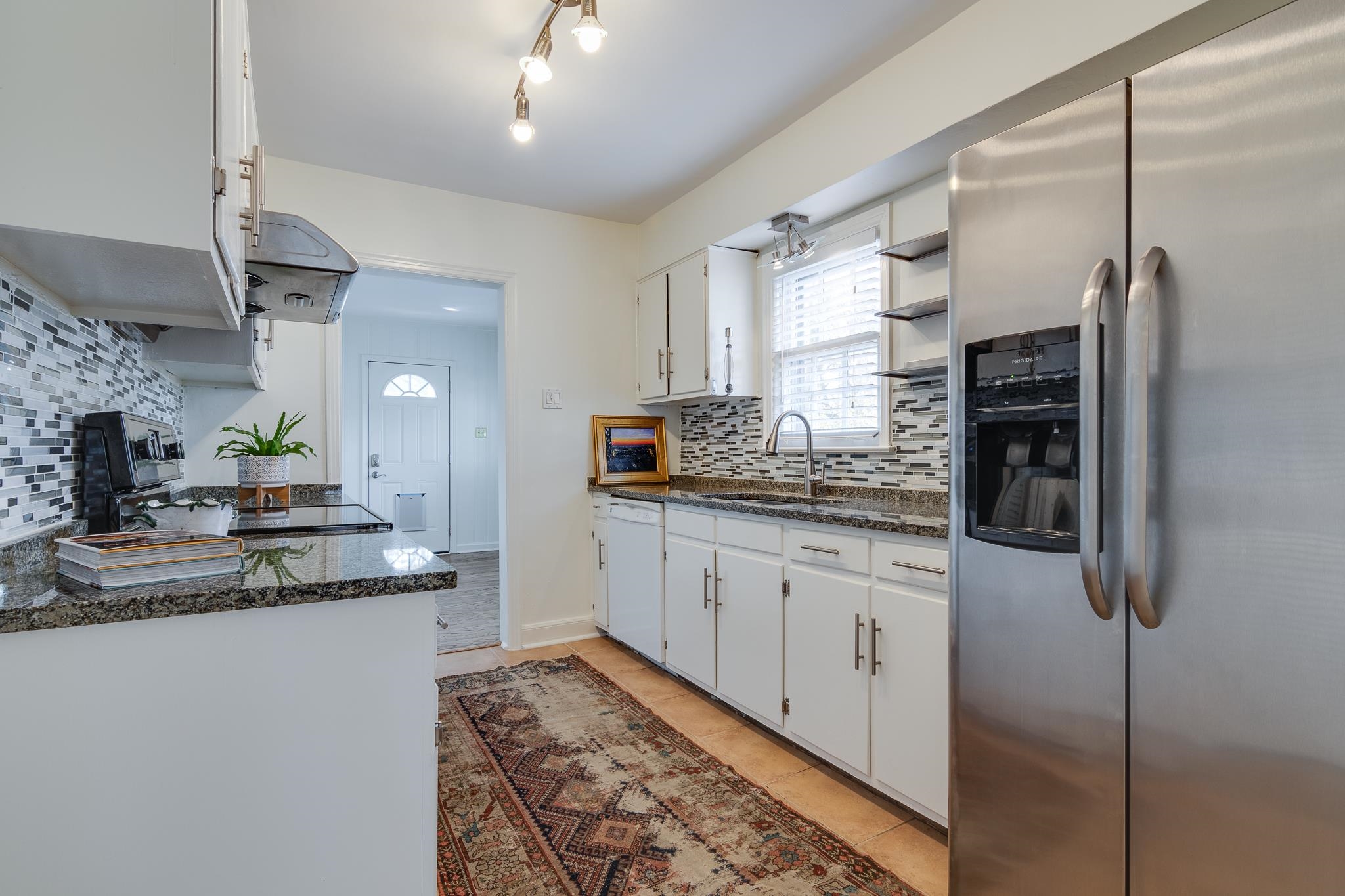 2767 Iroquois Road Memphis, TN 38111 - Photo 10 of 28 Kitchen with sink, range, stainless steel refrigerator with ice dispenser, tasteful backsplash, and light tile patterned floors