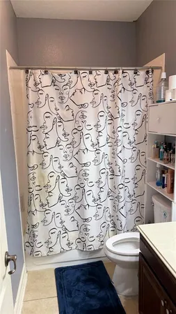 a bathroom with a toilet and a shower curtain