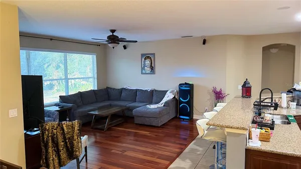 a living room with furniture a window and wooden floor