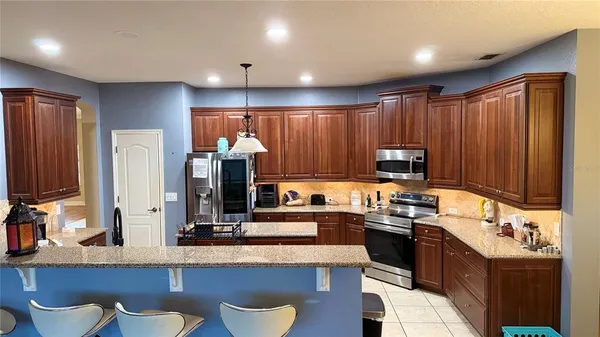 a kitchen with kitchen island granite countertop a sink counter top space appliances and cabinets