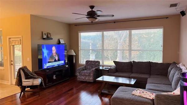a living room with furniture a flat screen tv and a large window