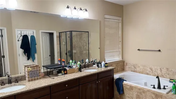 a bathroom with a bathtub double sink and mirror