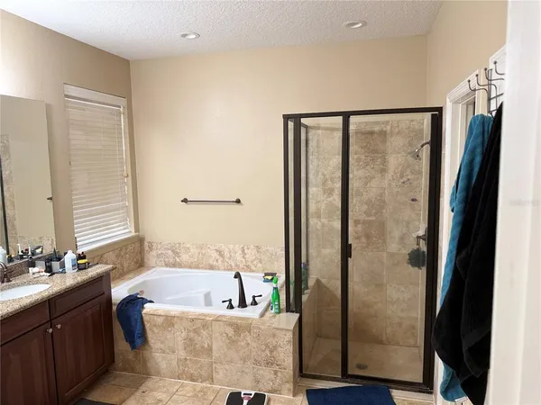 a bathroom with a granite countertop bathtub shower and sink