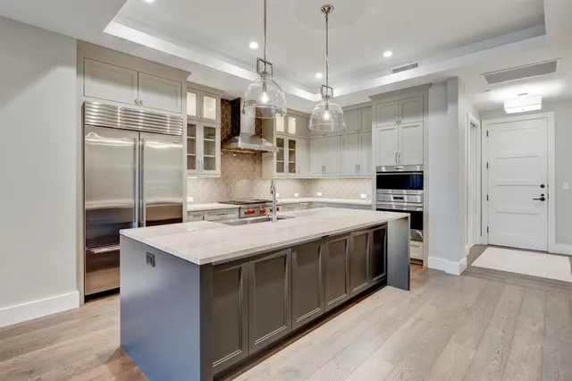 a kitchen with stainless steel appliances granite countertop a sink a stove and a refrigerator