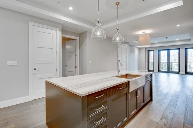 a spacious bathroom with a granite countertop sink a large mirror and a shower