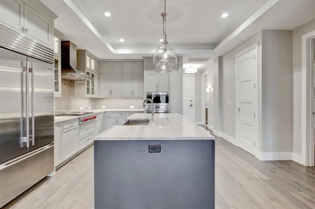 a kitchen with kitchen island a sink stainless steel appliances and cabinets