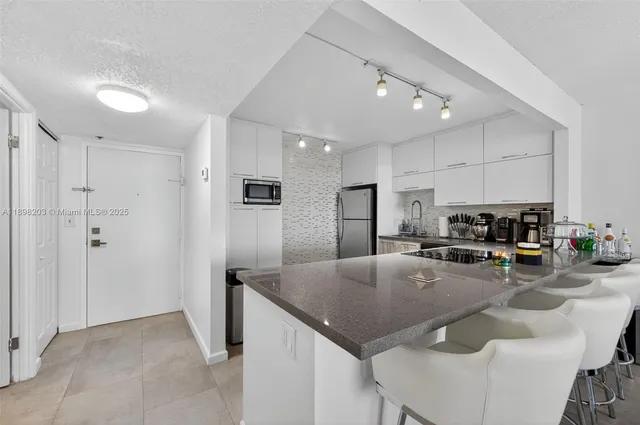 a kitchen with stainless steel appliances granite countertop a sink a refrigerator and a stove