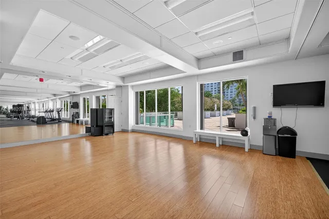 a view of a livingroom with furniture a fireplace wooden floor and windows