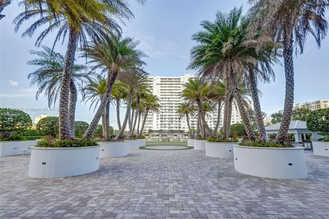 a view of a house with a yard and palm trees
