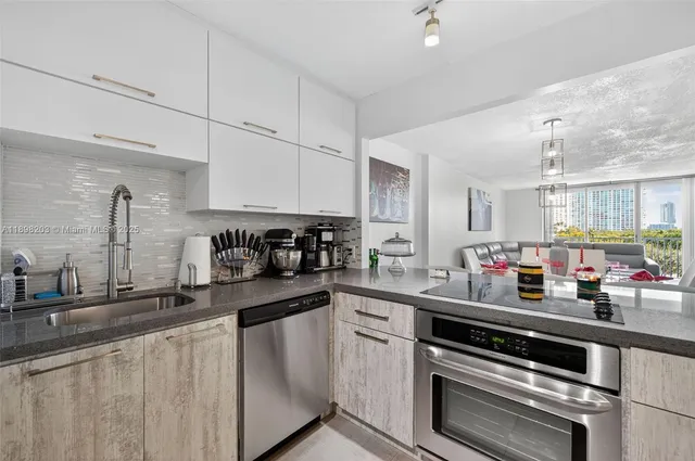 a kitchen with stainless steel appliances a sink dishwasher a stove and cabinets