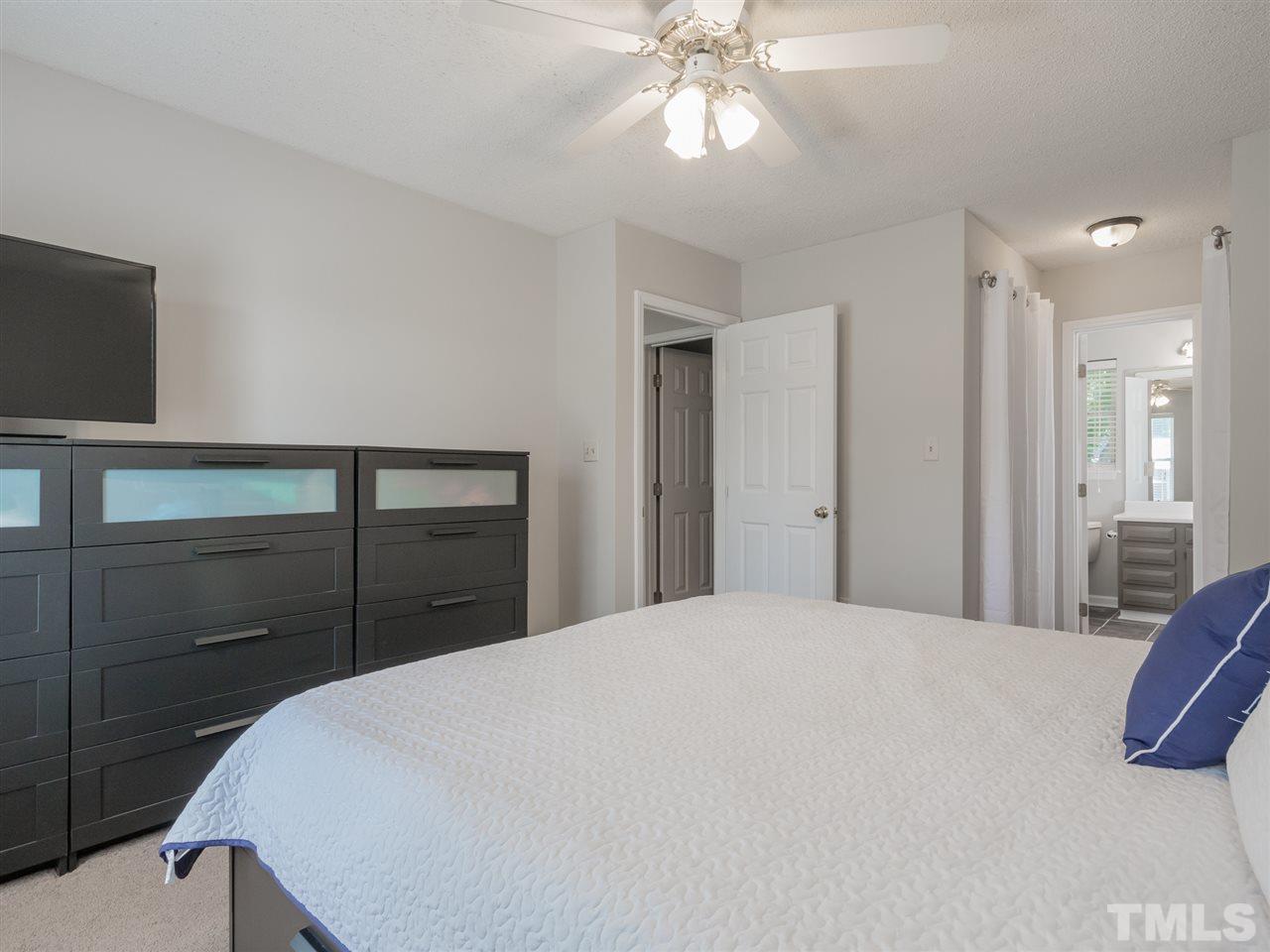 5402 Dorcas Street Raleigh, NC 27606 - Photo 11 of 18 a bedroom with a bed and a chandelier