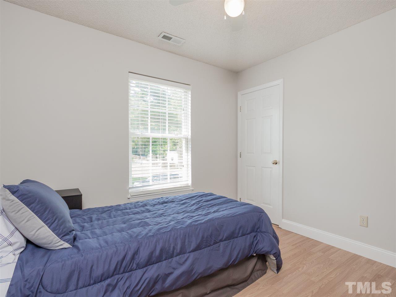5402 Dorcas Street Raleigh, NC 27606 - Photo 13 of 18 a bedroom with a bed and wooden floor