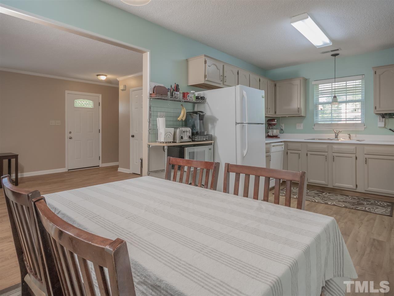 5402 Dorcas Street Raleigh, NC 27606 - Photo 8 of 18 a kitchen with stainless steel appliances granite countertop a kitchen island a stove a table and chairs