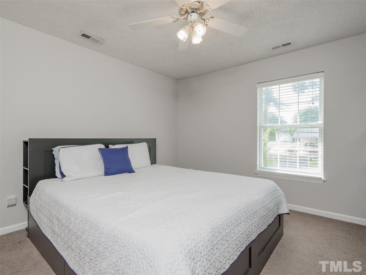 5402 Dorcas Street Raleigh, NC 27606 - Photo 10 of 18 a bedroom with a large bed and a chandelier