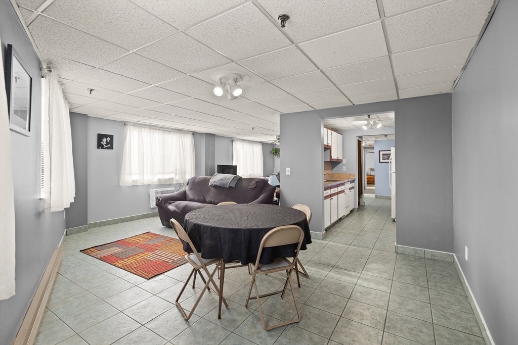 111 Foster Street, Unit 305 Peabody, MA 01960 - Photo 11 of 24 a living room with furniture a dining table and chairs