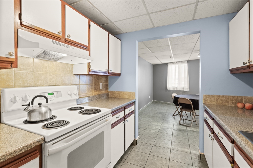 111 Foster Street, Unit 305 Peabody, MA 01960 - Photo 13 of 24 a kitchen with a sink stove and cabinets