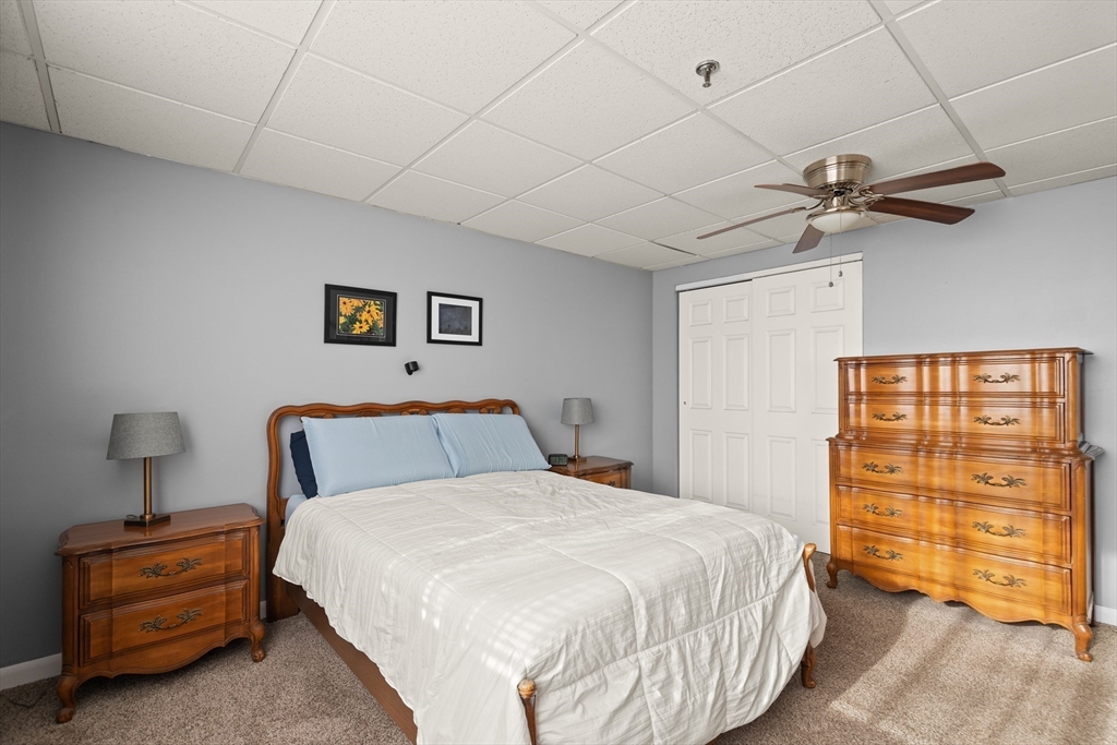 111 Foster Street, Unit 305 Peabody, MA 01960 - Photo 19 of 24 a bedroom with a bed and a chandelier
