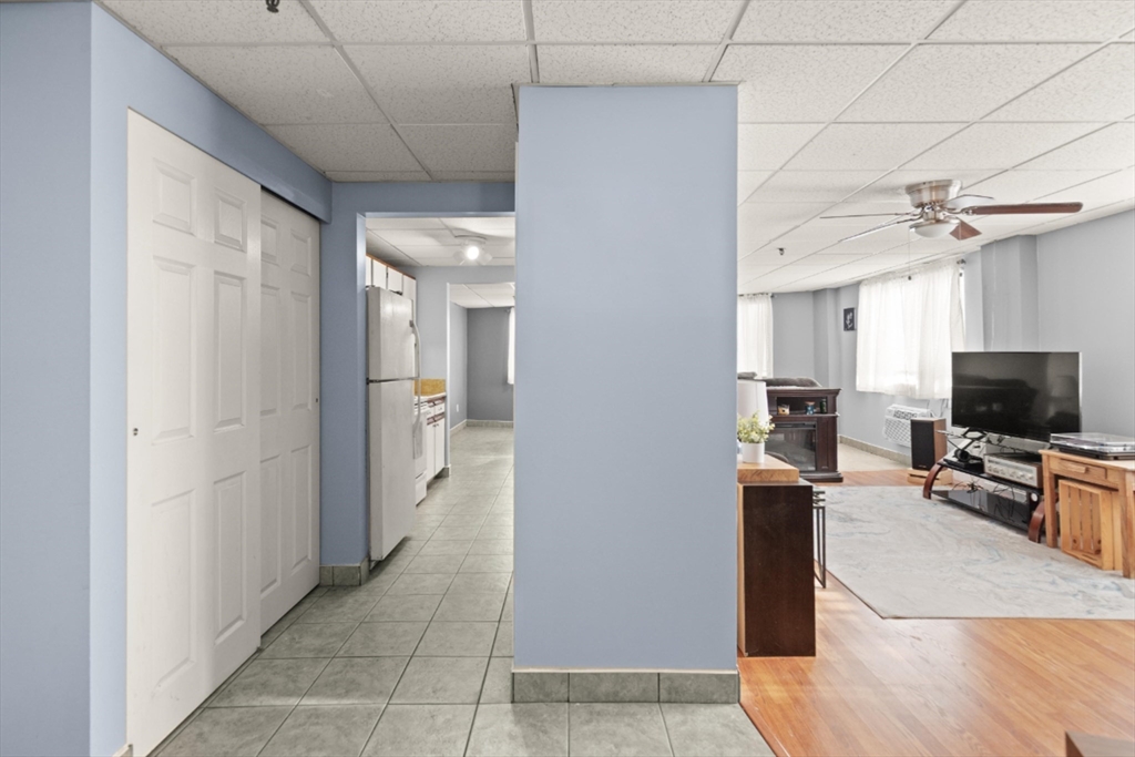 111 Foster Street, Unit 305 Peabody, MA 01960 - Photo 4 of 24 a living room with furniture and a flat screen tv