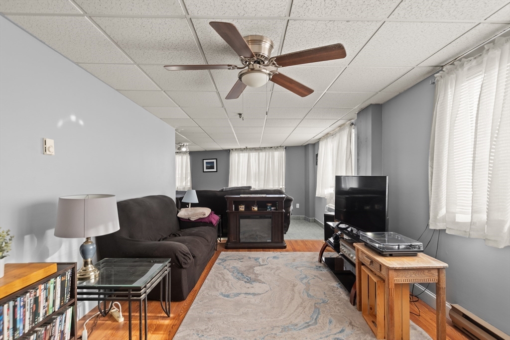 111 Foster Street, Unit 305 Peabody, MA 01960 - Photo 7 of 24 a living room with furniture a flat screen tv and a window