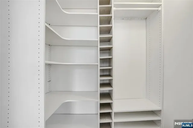 a view of walk in closet with empty racks